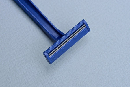 one blue plastic razor lies on a gray table