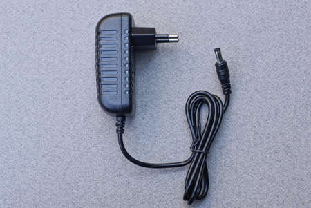 one big black plastic charger lies on a gray table