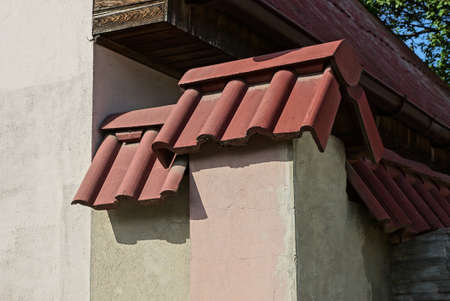 gray concrete corner of house wall under red tiles on the street
