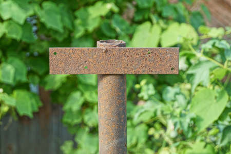 one brown rusty metal pipe with iron plate outdoors on a green backgroundの写真素材