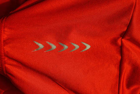 red fabric texture from sports crumpled clothing with gray arrow reflector