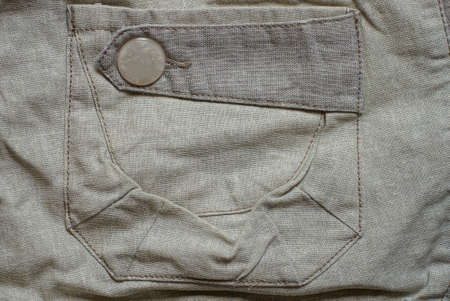 one plastic button on the pocket of a gray cloth garmentの写真素材