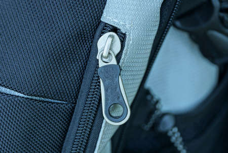 one white black metal zip on the fabric of a large backpackの写真素材