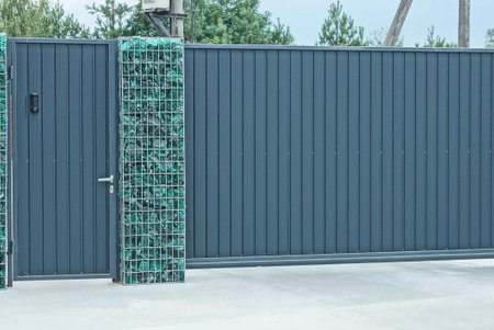 a large gray metal gate and a closed door on the street
