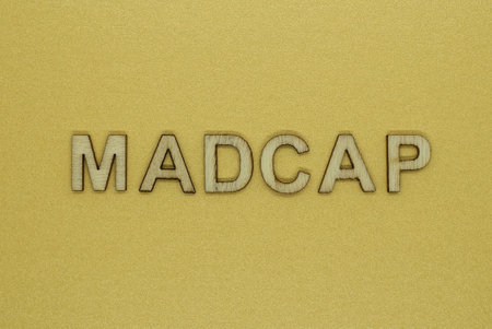 word madcap made from wooden letters lies on a yellow tableの写真素材