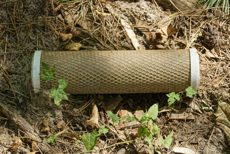 rubbish from one old brown paper filter lies on gray ground outside