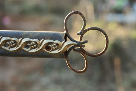 part of a gray iron rusty cross with a pattern on the street in the cemeteryの写真素材