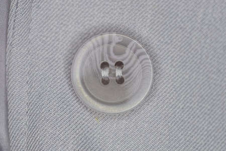 one big plastic button on a gray garment fabricの写真素材