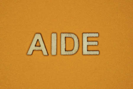 gray word aide made of wooden letters on brown background