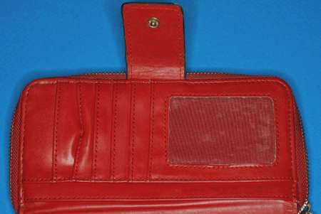 one open red leather wallet with pockets lies on a blue table