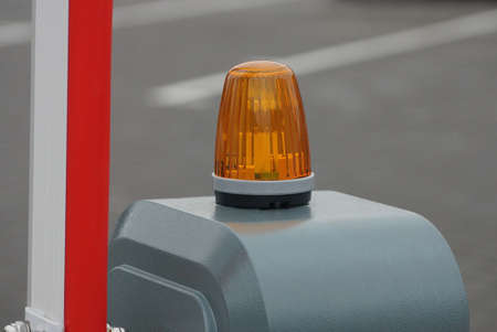 one signal lamp on a gray metal barrier post on the street near a gray road