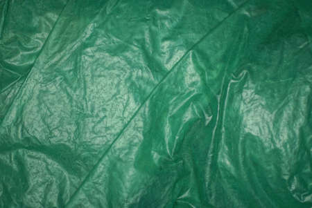 green plastic background of a piece of crumpled cellophane packageの写真素材