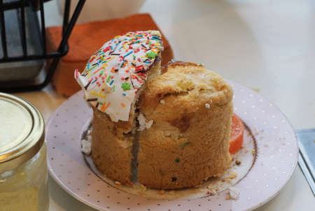 food from a brown cut bun on a white plate on the table in the room