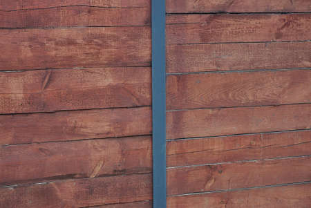 brown red wooden texture from old boards with black metal plate in the fence wall