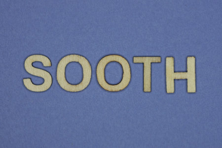 gray word sooth in small wooden letters on a blue backgroundの写真素材