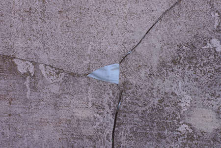 gray stone texture of a concrete wall with a hole and cracks