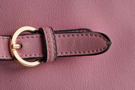 one yellow metal latch with a ring on the strap of a leather bagの写真素材