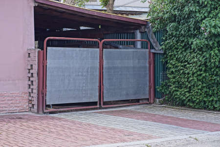 one rural closed metal gate on the pavement in the street
