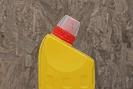 one yellow plastic bottle with red cork on a gray backgroundの写真素材