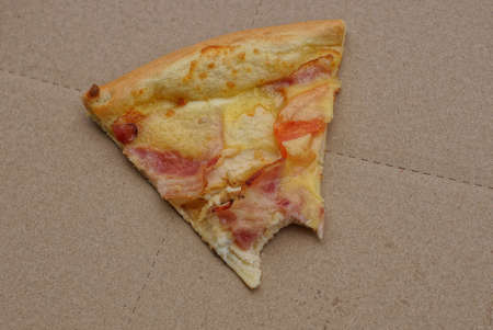 food from piece of fried pizza lies on gray paper packaging boxの写真素材