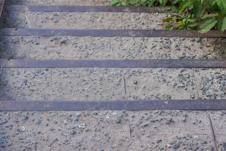 gray old metal concrete steps on a large staircase of a city streetの写真素材