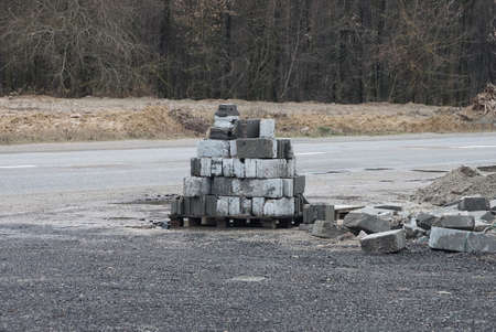a pile of white gray bricks on a pallet stands on the pavement on the streetの写真素材
