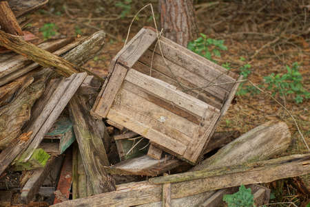 a pile of old gray wooden boards and a crate on a rural streetの写真素材
