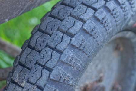 part of a black car tire on a gray wheel of an old carの写真素材