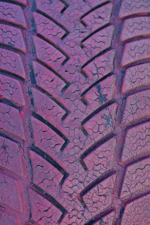 red plastic background from an old dirty car tire with cracksの写真素材
