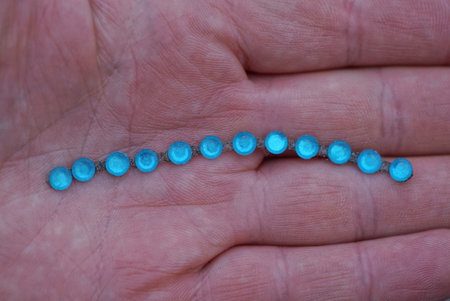 part of the decoration from blue turquoise beads lies on the palm