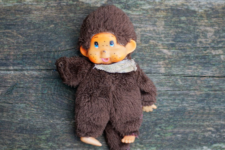 one small brown plush toy monkey lies on a gray table
