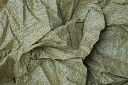 green background of crumpled synthetic fabric on clothesの写真素材
