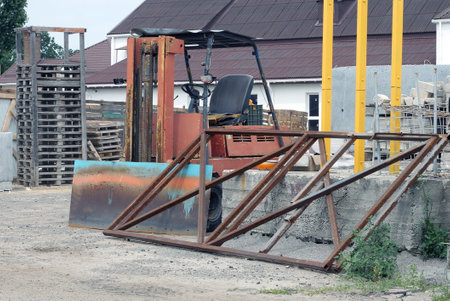 part of an industrial warehouse on the street with an old auto forklift and a metal brown frameの写真素材
