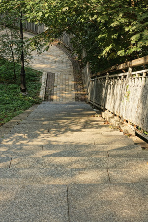 decorative concrete staircase with steps near stone gray pavement in summer park