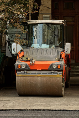 one industrial auto paver stands on a gray asphalt road on a city streetの写真素材