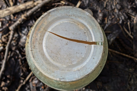 one old broken plastic white cap with a crack on a glass jar outdoors