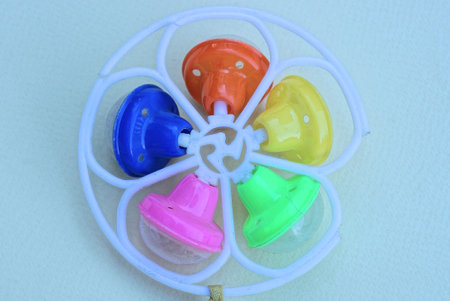 <p>one round plastic colored small dirty toy rattle lies on a gray table</p>