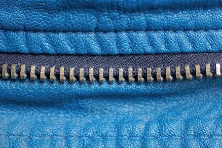 part of a zip with gray metal teeth on black fabric and blue leather clothesの写真素材