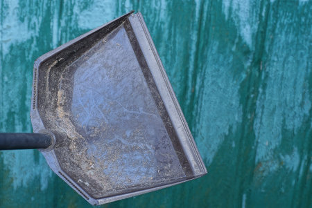one black dirty plastic scoop on a green backgroundの写真素材