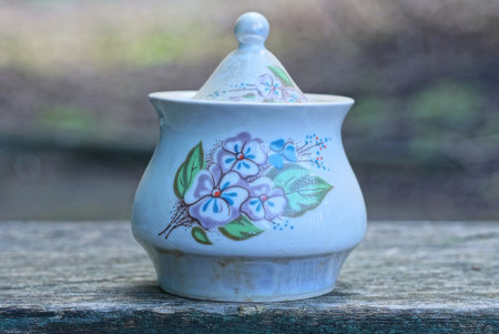 one white closed ceramic sugar bowl with a color pattern stands on a gray tableの写真素材