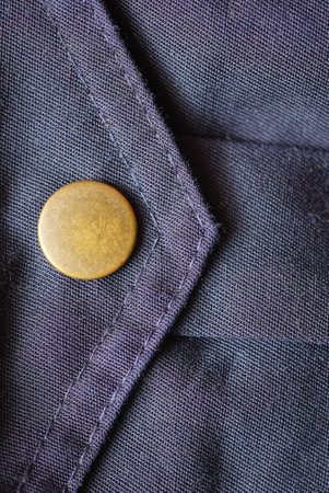 one brown metal rivet button on blue fabric pocket on clothesの写真素材