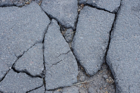 gray texture of asphalt on the road with cracks in the streetの写真素材
