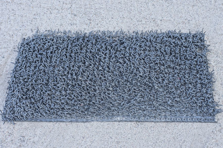 one black rectangular old rubber mat lies on gray asphalt in the streetの写真素材