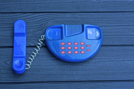 one small old blue plastic phone toy with red buttonsの写真素材