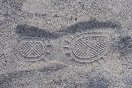 shoe sole print on the gray sand of the road in the streetの写真素材