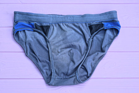 one gray panty made of crumpled fabric lies on a pink wooden tableの写真素材