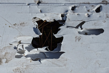 white gray metal texture from an old dirty aluminum wall with a hole