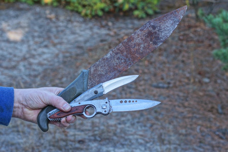one man holding three knives on the street