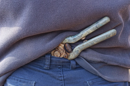 one old pruner sticks out from the waistband of his pants behind his back