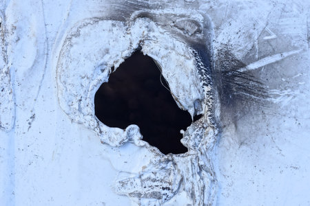 a piece of old gray white plastic with a black holeの写真素材